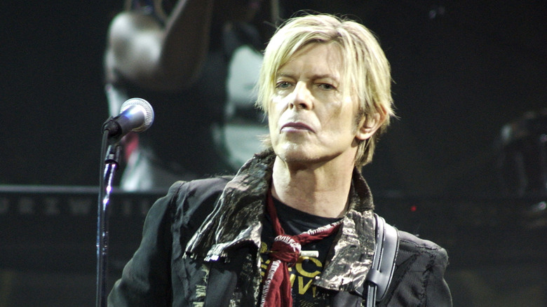 David Bowie on stage with microphone in 2004