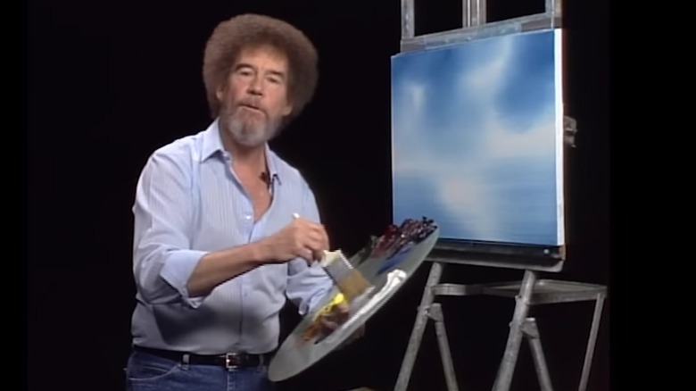 bob ross painting blue shirt black background