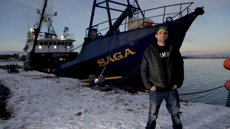 Jake Anderson standing on a snowy dock in front of his ship, the Saga.