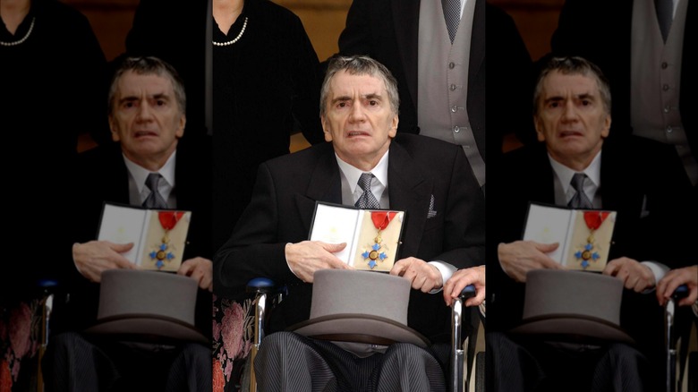 Dudley Moore wheelchair Buckingham Palace holding medal