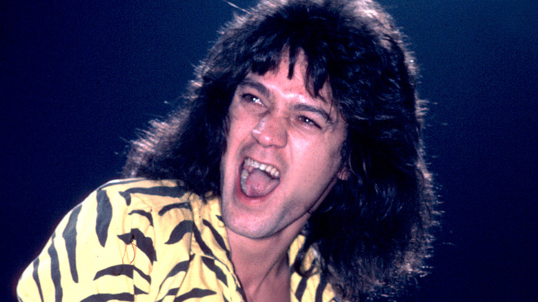 eddie van halen playing guitar yellow shirt