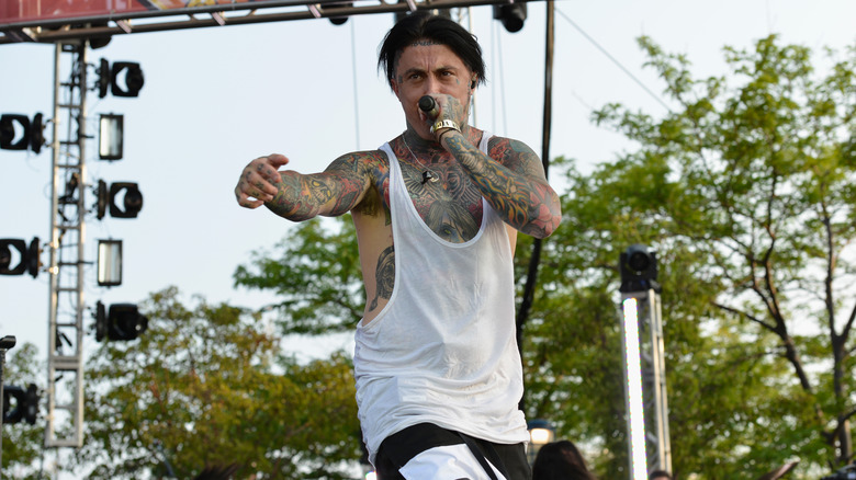 Ronnie Radke wearing a white vest and singing on stage