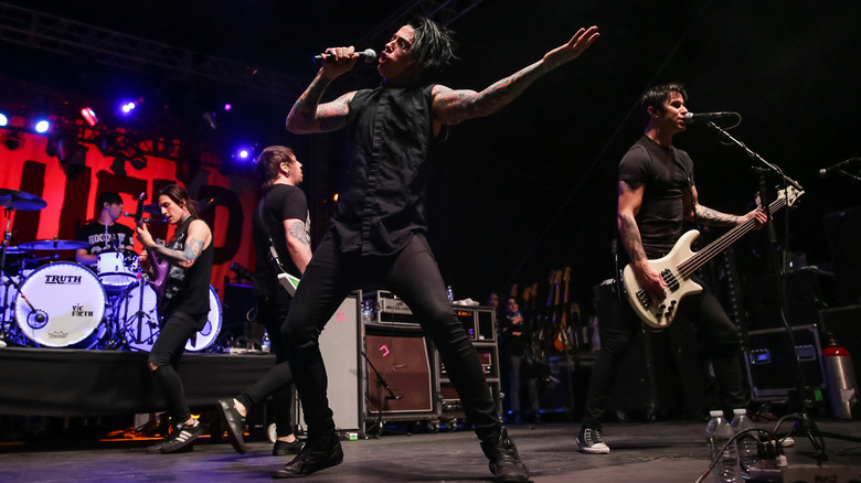 Falling in Reverse playing on stage dressed in black