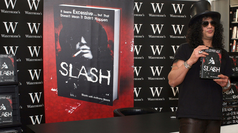 Slash hat holding his autobiography with poster