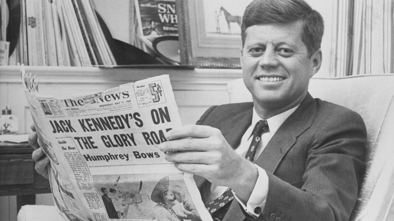 John F. Kennedy reading a paper about his political victory