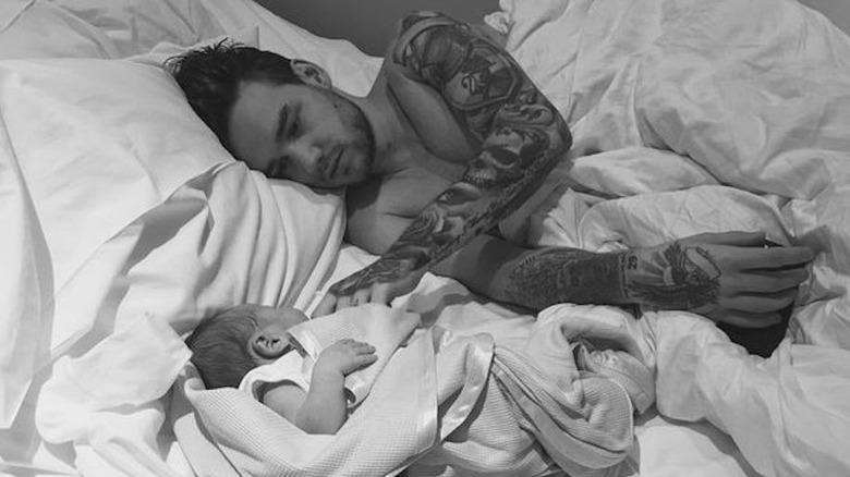 Shirtless Liam Payne lying in bed with infant son Bear