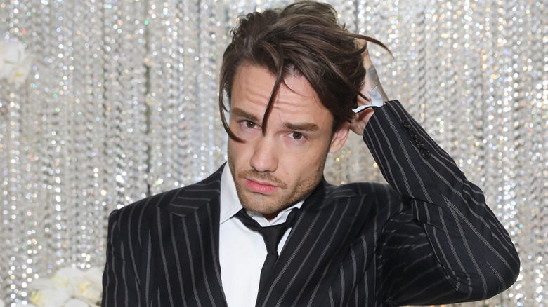 Liam Payne with tousled hair in front of a glittering background