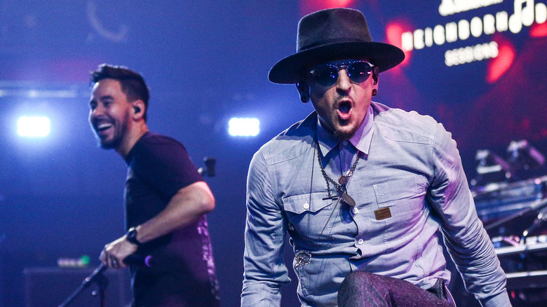 Chester Bennington wearing a hat and glasses, having fun on stage