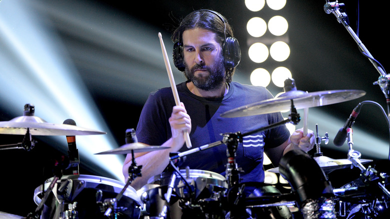 Rob Bourdon wearing headphones and playing drums