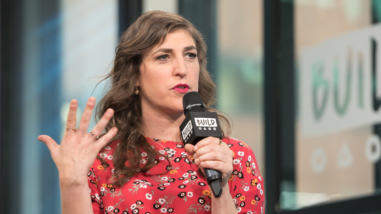 mayim bialik speaking hand up microphone