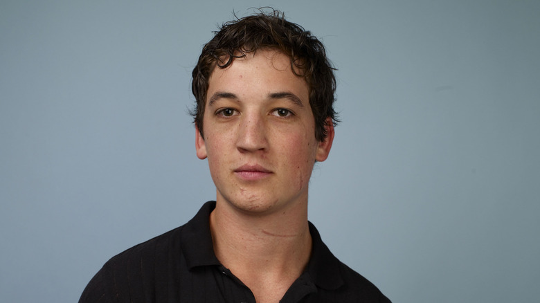 Miles Teller wearing black shirt and posing