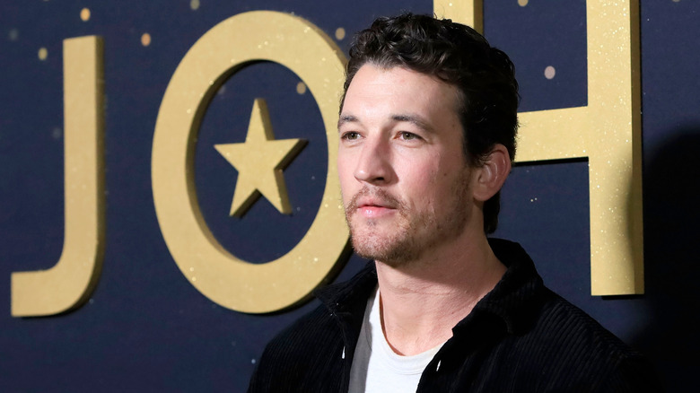 Miles Teller looking to the left at press event