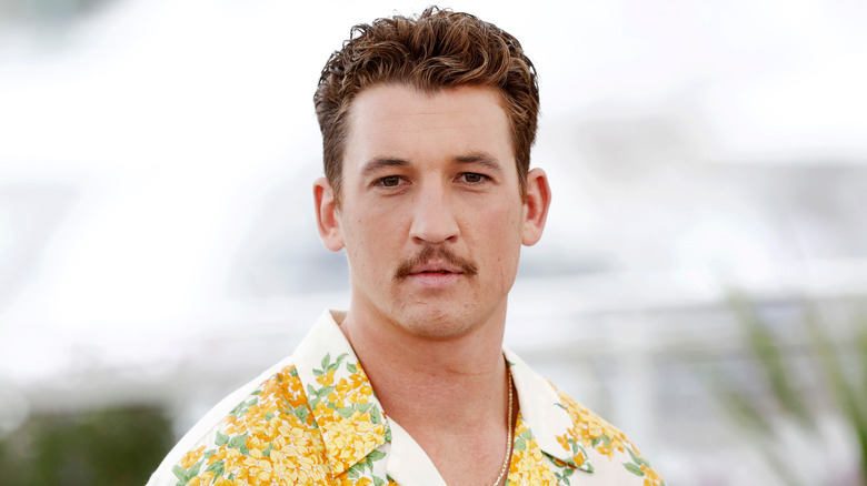 Miles Teller posing in a Hawaiian shirt