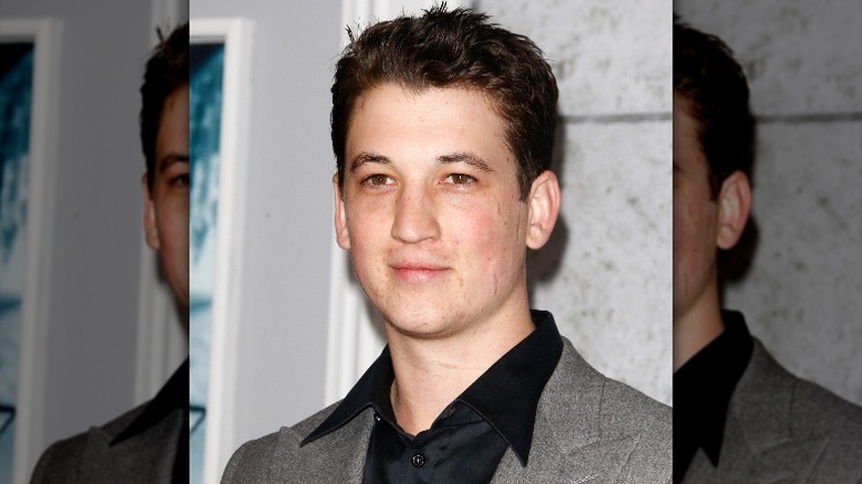 A young Miles Teller wearing suit and smiling