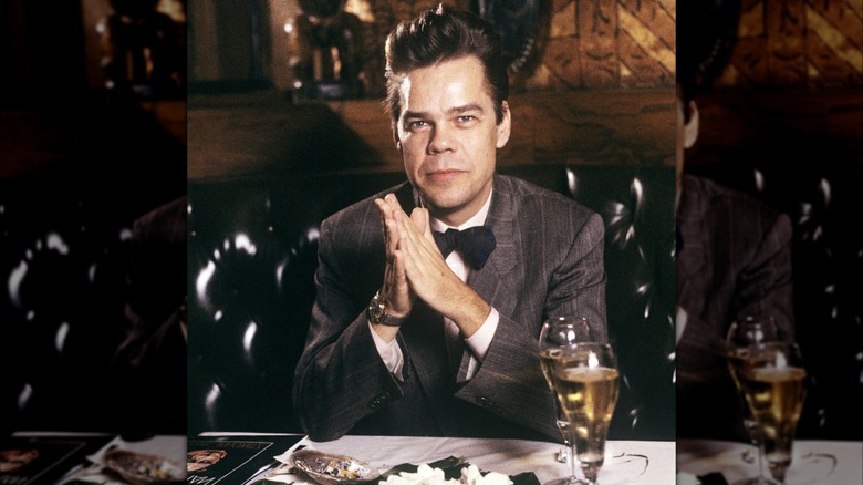 David Johansen as Buster Poindexter sitting at a table