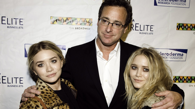 Bob Saget hugging Mary-Kate and Ashley Olsen as they pose for a photo