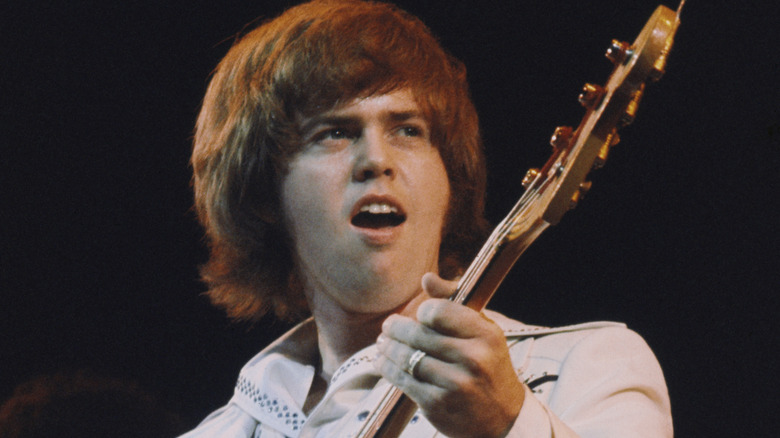 merrill osmond mouth open while playing bass on stage in the 70s