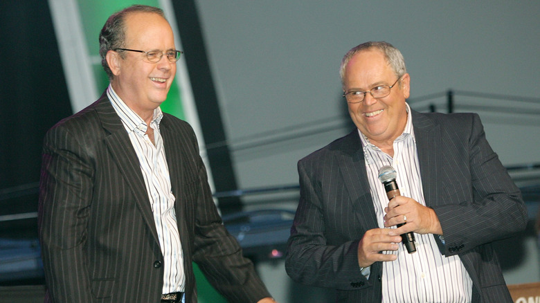 virl osmond and tom osmond smiling onstage in matching pinstripe suits