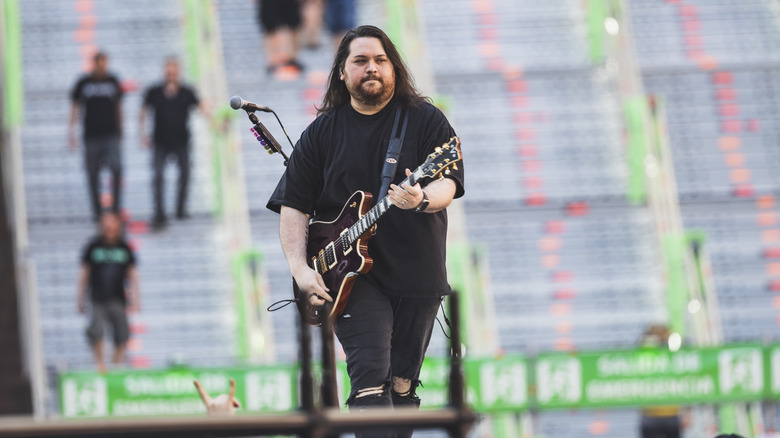 Wolfgang Van Halen onstage at outdoor concert with guitar