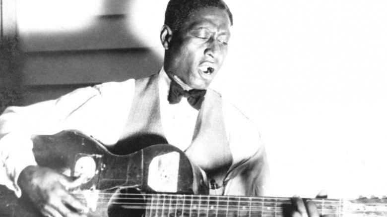 Leadbelly playing guitar and singing