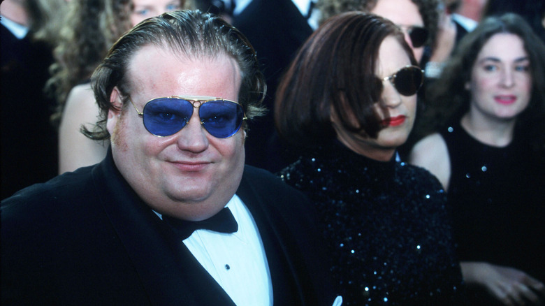 Chris Farley in blue aviator glasses and tuxedo at an award ceremony