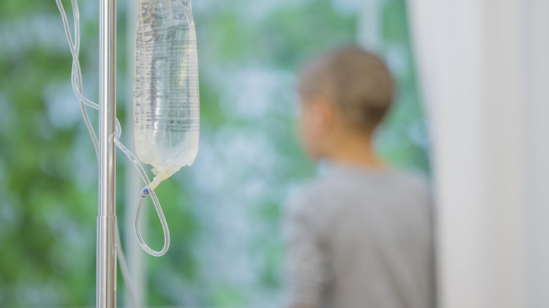 Child with cancer looks out window