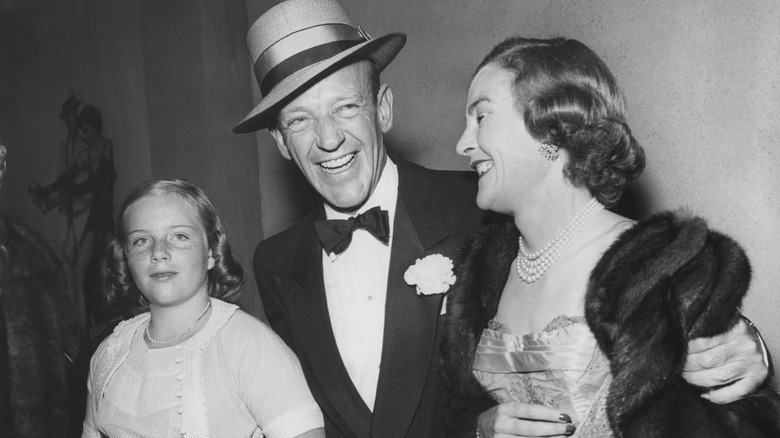 Fred Astaire and Phyllis Potter smile with their daughter