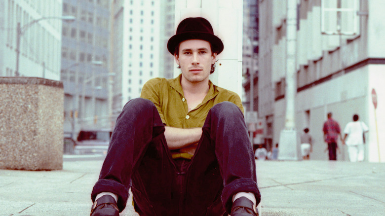 Jeff Buckley sitting on sidewalk