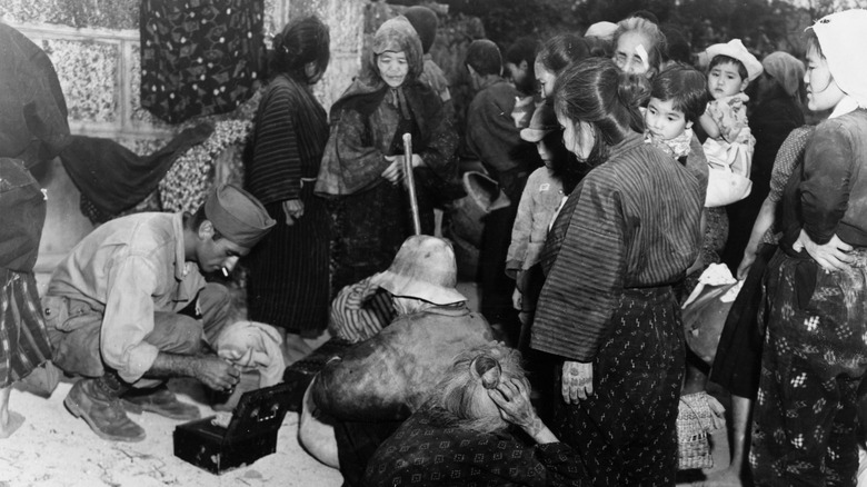 Okinawan refugees being cared for by American soldiers after World War II