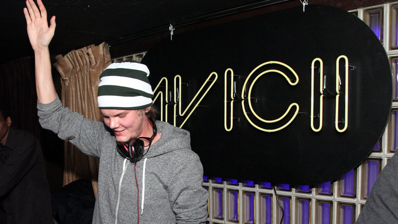 Tim Bergling Avicii in front of a sign of his name