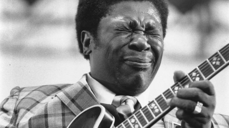 B.B. King playing guitar, squinting