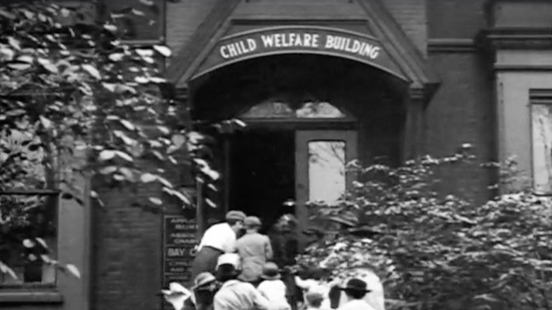 Children are escorted into an orphanage