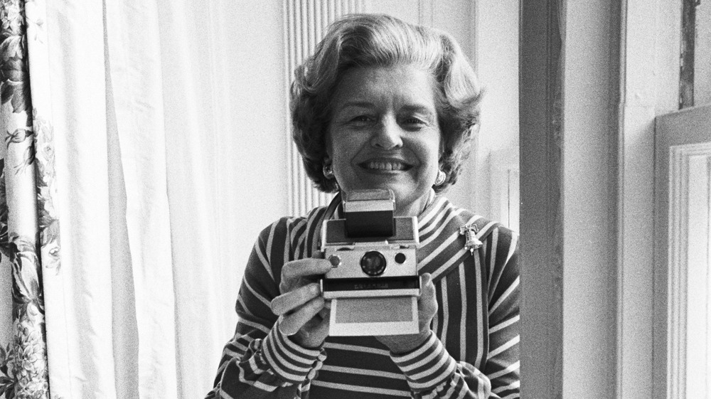 Betty Ford posing with a camera