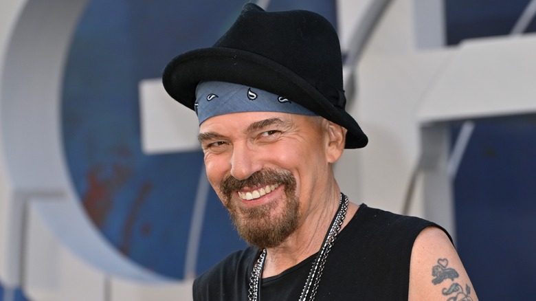 Billy Bob Thornton smiling in a black hat with a goatee