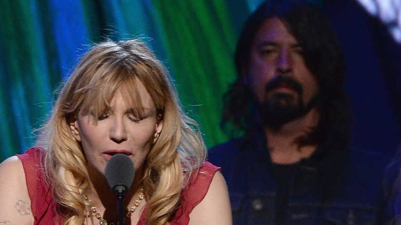 Dave Grohl standing behind Courtney Love