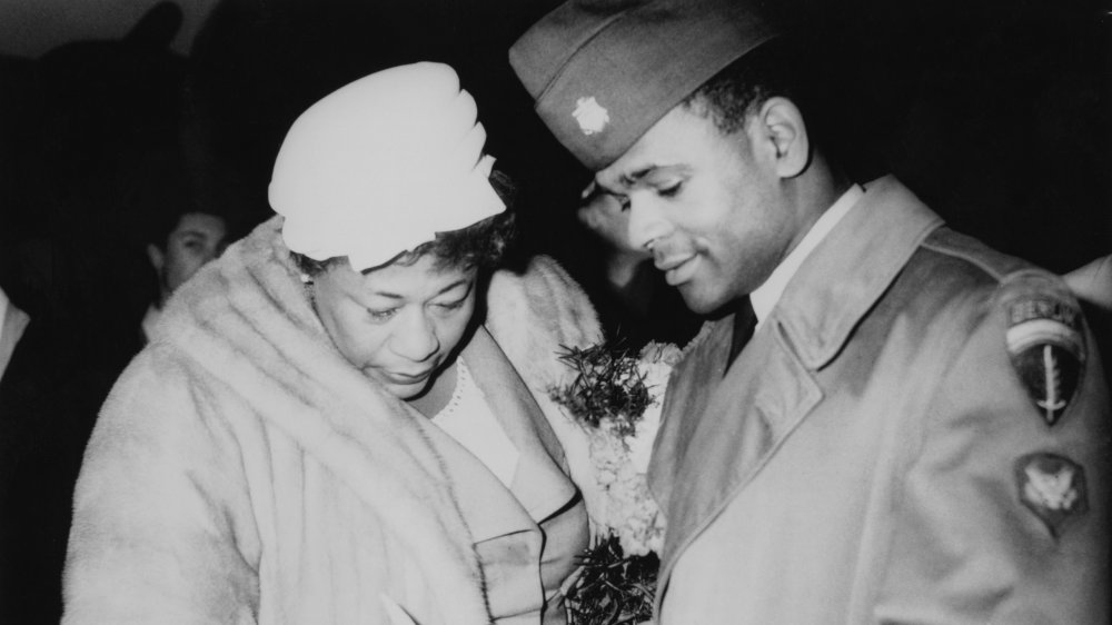 Ella Fitzgerald signs an autograph of a serviceman