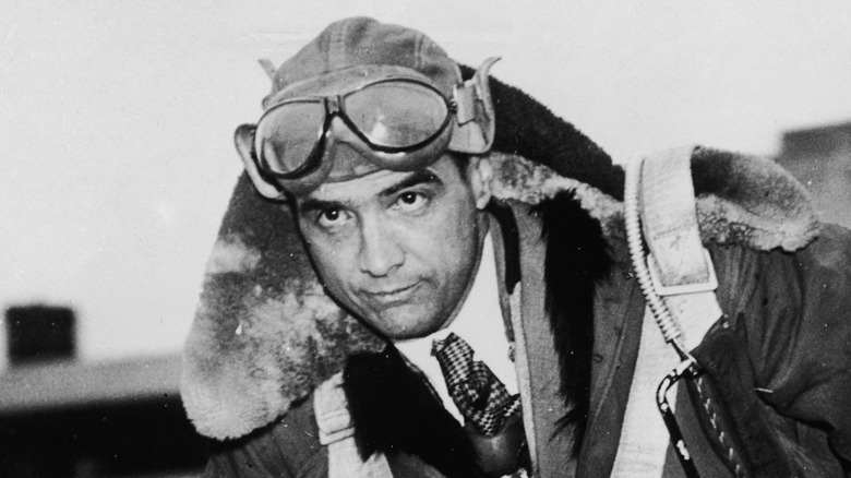Howard Hughes climbs out of a plane
