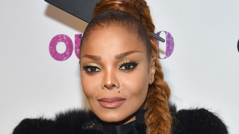 Janet Jackson with fur coat and a braid