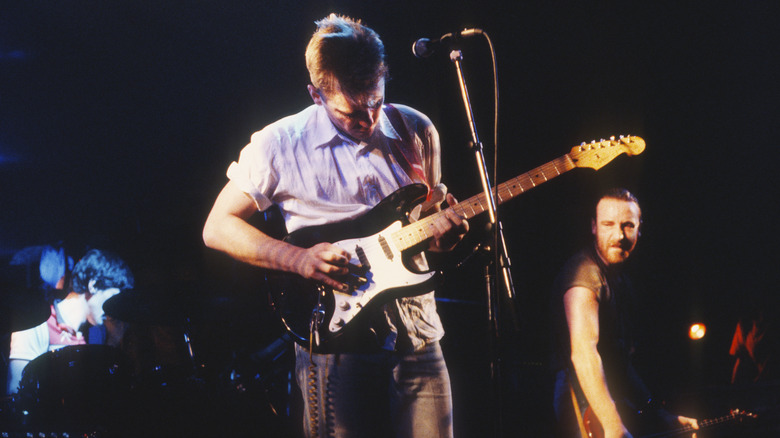 Bernard Sumner, Stephen Morris, and Peter Hook performing