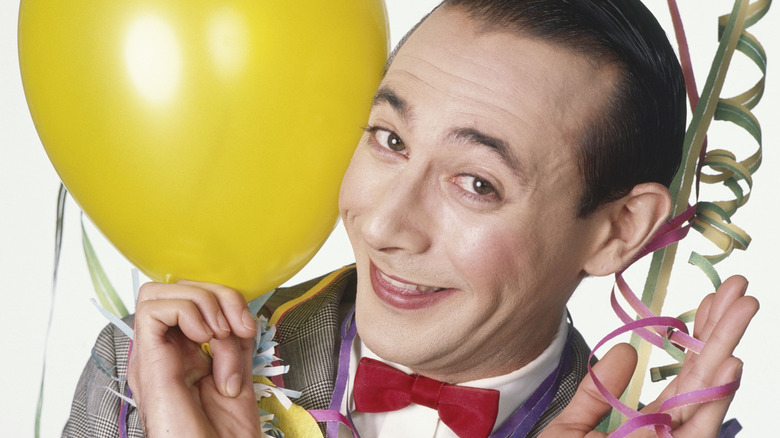 Paul Reubens as Pee-wee Herman holding balloons