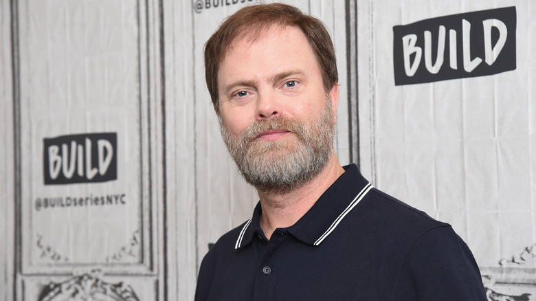 Rainn Wilson in front of a wall