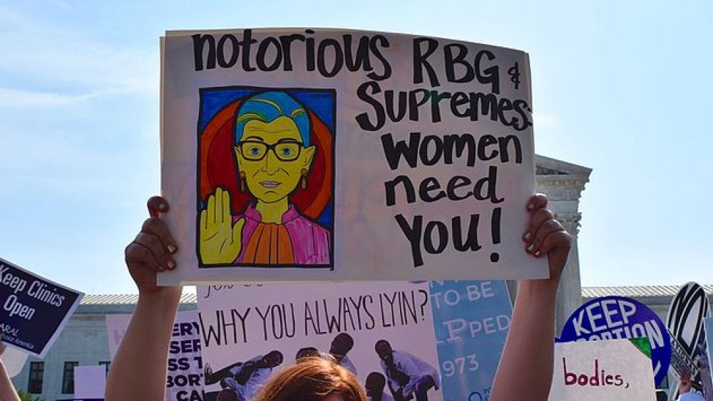 A protester holds a sign that reads "Notorious RBG & Supremes: Women need you!" at a pro-choice rally