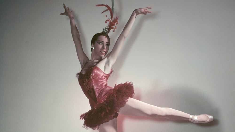 Maria Tallchief in red costume and hands in air