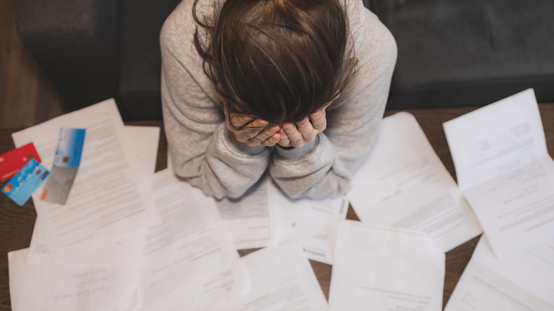 Shocked stressed young woman reading document letter from bank about loan debt financial problem