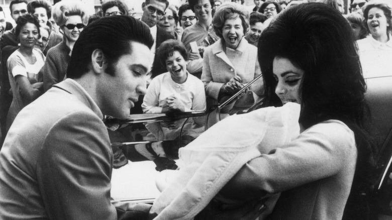 Elvis and Priscilla Presley holding baby Lisa Marie