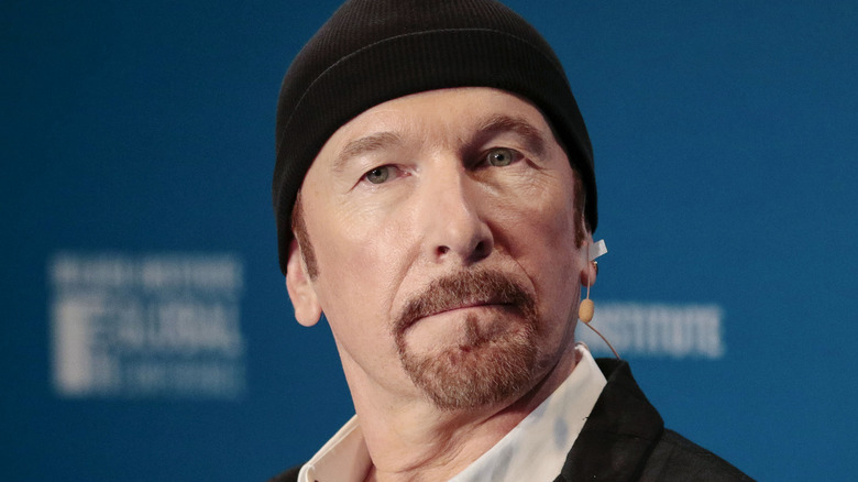 The Edge wearing black beanie looking serious