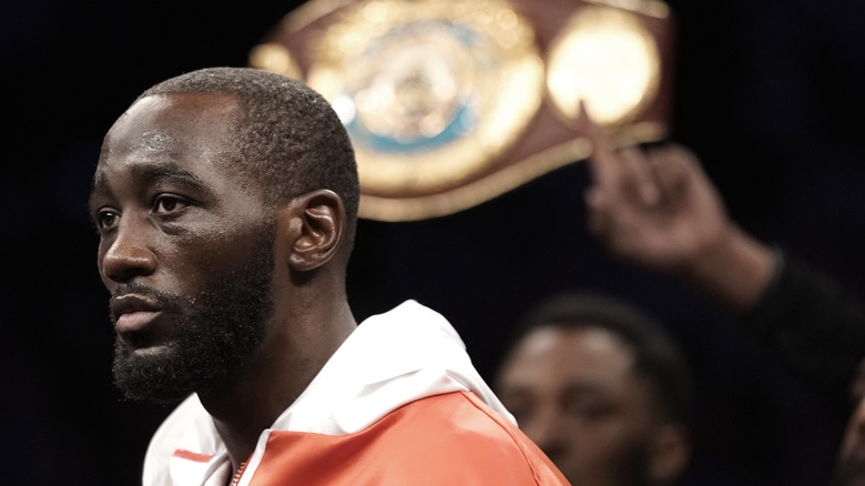 Terence Crawford with a belt being held behind him