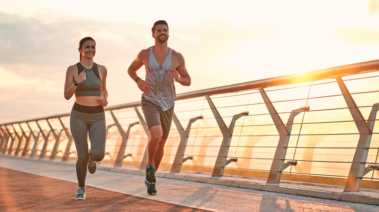 two people running at sunset