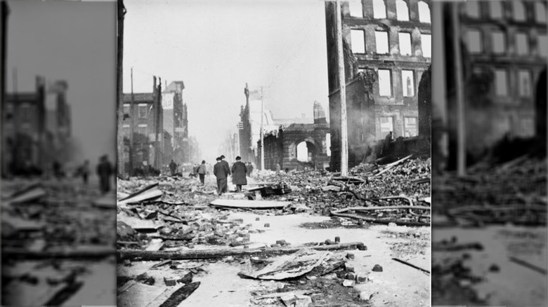 people standing on burned street with debris