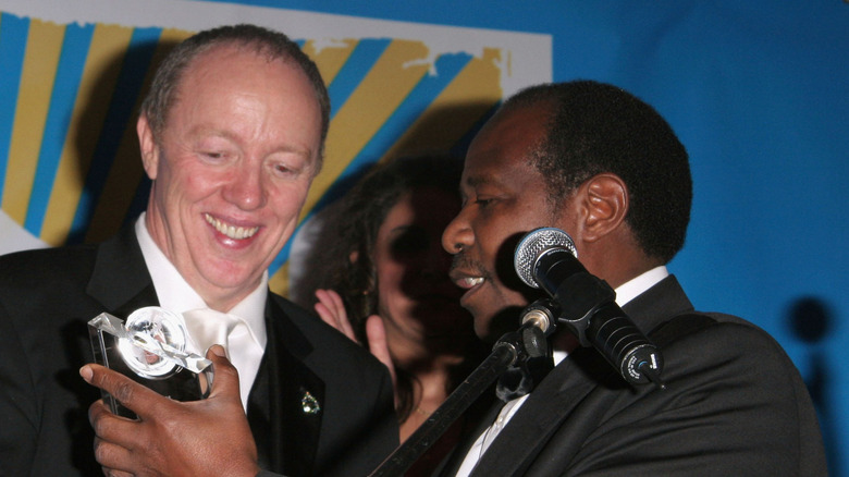 terry george and paul Rusesabagina accepting award by microphones